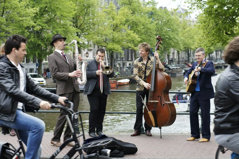 A band playing on a sidewalk