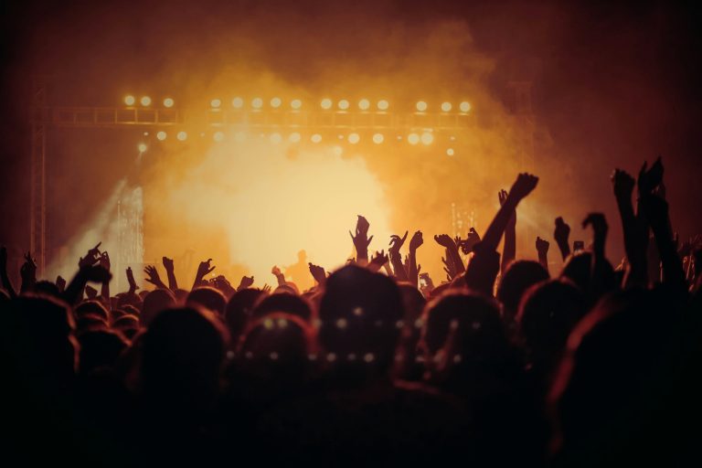 A crowd in front of a lit stage