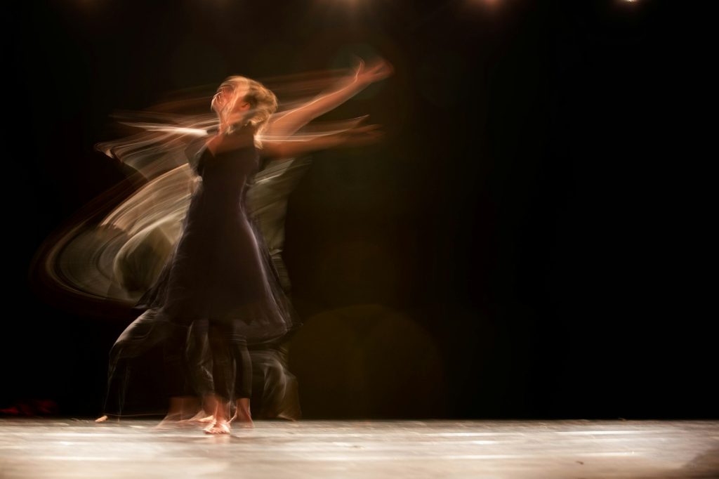 A dancer mid-turn under a stage light