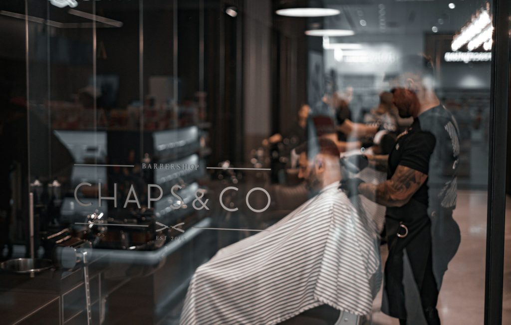 A barber at work, seen through the shop window